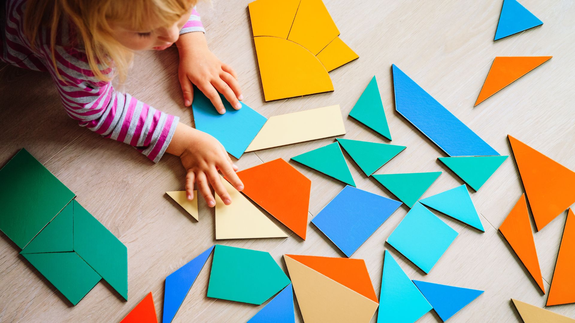Child playing with colorful geometric shapes