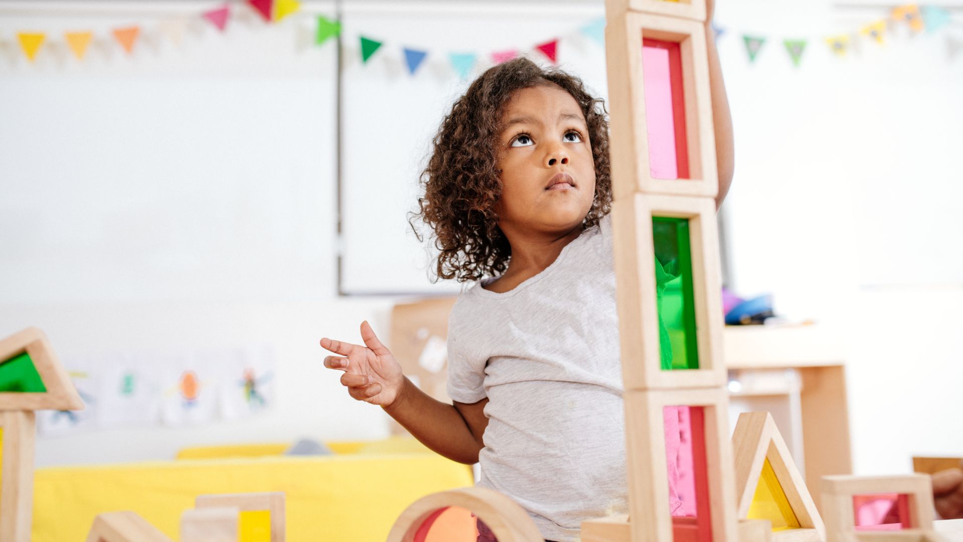 Child building with colorful wooden blocks.