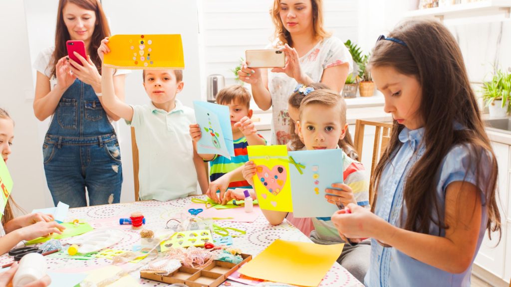 Children displaying handmade cards in a craft class.