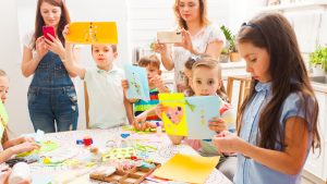 Children displaying handmade cards in a craft class.