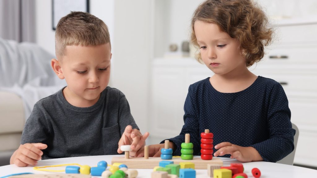 Children playing with educational toys at table.