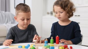 Children playing with educational toys at table.